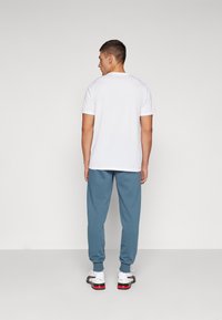 Puma LOGO PANTS - Teplákové kalhoty - gray skies