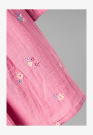 Puhaszövetből készült rózsaszín ing, finom virágmintás hímzéssel, pasztell színekben. Kiemelkedő színek: világoskék és krémszín.