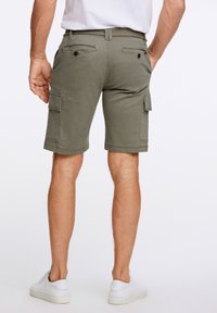 Olivgrön cargoshorts i bomull, med flera fickor, midja med bältesöljor och en nederkant som ligger ovanför knäet.