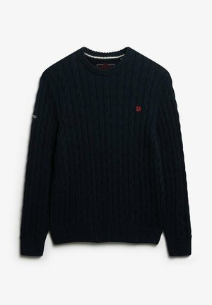Suéter de punto trenzado azul marino con cuello redondo y puños acanalados. Pequeño logo rojo en el lado izquierdo del pecho. Material texturizado y cálido.