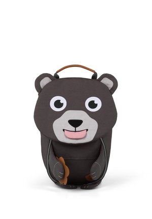 Children’s backpack shaped like a dark brown bear with large eyes, pink tongue, ears, and front pocket paws holding a flower.