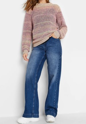 Mønstret striktrøje med lange ærmer og ribbede manchetter, sammen med højhofte, vide blå denim jeans. Hvide sneakers fuldender looket.