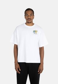 White cotton t-shirt featuring a cartoon graphic on the chest. Short sleeves, loose fit, and round neckline.