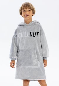 Lichtgrijze gewatteerde hoodie, gemaakt van pluche stof met lange mouwen, met een voorzak en de tekst "CHILL OUT" in wit en zwart gedrukt.