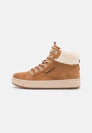Botte d'hiver montante en daim marron avec doublure en polaire blanche, bout rond, semelle en caoutchouc beige et fermeture à lacets avec œillets et crochets métalliques.