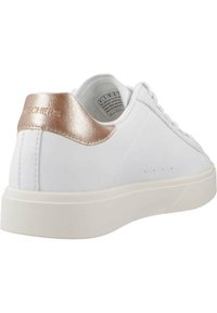 Zapatilla blanca con un acabado de cuero suave, acento en rosa dorado en el talón y una suela de goma blanca gruesa. Diseño minimalista con costuras sutiles.