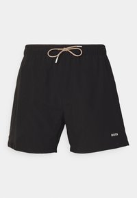 Sorte svømmeshorts med elastisk liv og beige snor, sidelommer og hvit "BOSS"-logo nederst på kanten.