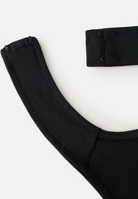 Tirante de sujetador de tela negra con superficie texturizada, cierre ajustable y diseño de soporte con forma suave y curvada.
