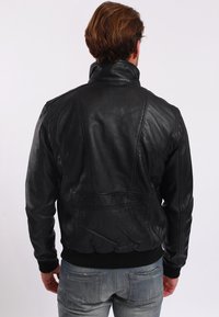Schwarze Lederbomberjacke mit hohem Kragen, gerippten Bündchen und Saum. Mit Nahtdetails und einer glatten, strukturierten Oberfläche.