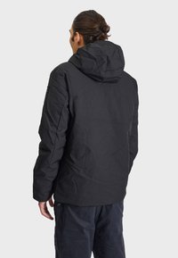 Čierna zateplená bunda s kapucňou, s hladkou textúrou a jednoduchým dizajnom. Obsahuje značkovú nášivku na rukáve.