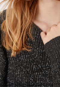 Czarny, dzianinowy sweter z teksturowanym wzorem i metalicznymi akcentami, z dekoltem w kształcie litery V i ściągaczami przy mankietach.