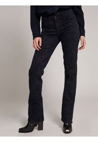 Jeans neri a vita alta, svasati, realizzati in tessuto testurizzato con un sottile motivo rettile. Presentano un design a cinque tasche.