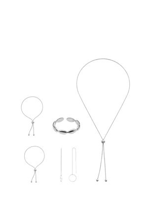 Set aus sechs silbernen Schmuckstücken, darunter verstellbare Armbänder, eine Manschette, eine lange Halskette und zwei Kettendrahtringe auf weißem Hintergrund.
