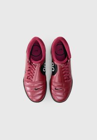 Sapatilhas de couro vermelho com um design acolchoado, acentos em preto e marca Nike. Apresentam um fecho tradicional com atacadores e sola interior acolchoada.