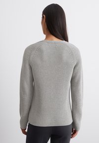 Maglione grigio lavorato a maglia con un design a coste testurizzato, maniche raglan e scollatura rotonda, con cuciture dettagliate lungo i lati.