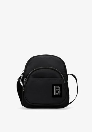 Bolso bandolera negro hecho de nailon con una textura suave, que cuenta con un bolsillo frontal con cremallera, herrajes plateados y un parche de logo.