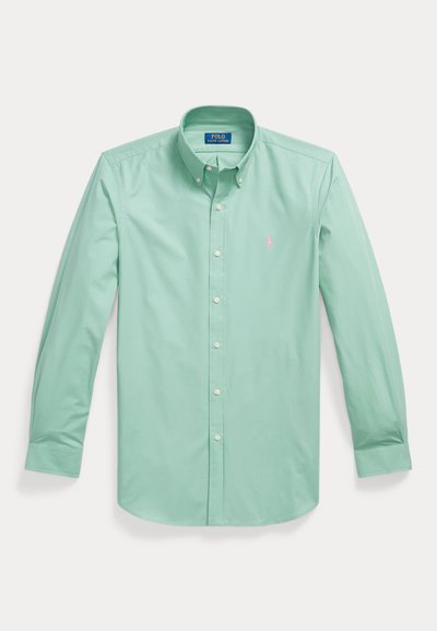 Lysegrøn langærmet skjorte med knapper og knaplukket krave samt lille pink broderet logo på venstre bryst.