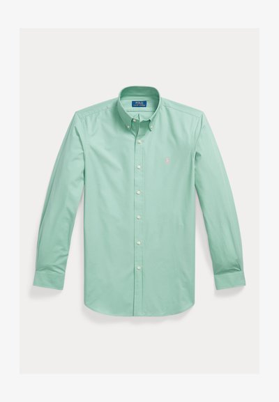 Lysegrøn langærmet skjorte med knapper og knaplukket krave samt lille pink broderet logo på venstre bryst.
