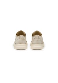 Sneakers in pelle beige con texture liscia, design minimalista e suola in gomma a profilo basso caratterizzata da un motivo a puntini sulla parte inferiore.