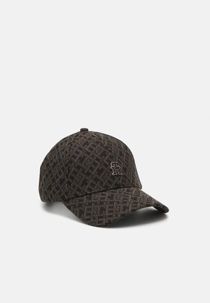 Brun og sort mønstret baseballkasket med buet skygge og et lille metal logo på frontpanelet mod en ensfarvet baggrund.