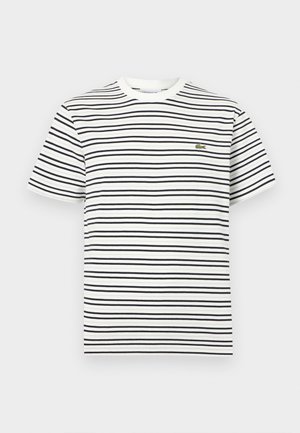 White short-sleeve t-shirt with black horizontal stripes and a small green crocodile logo on the left chest.