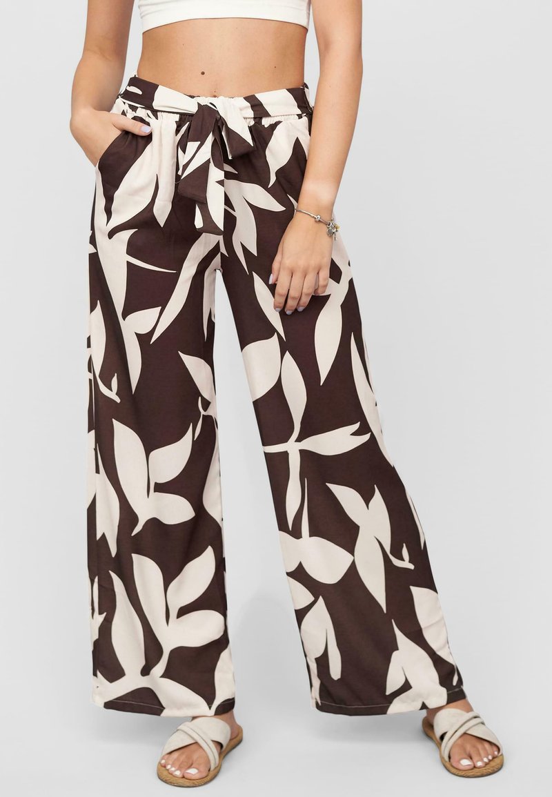 Pantalons marron à pattes larges avec un motif de feuilles crème, dotés d'une taille élastique et d'une ceinture nouée. Comprend des poches latérales et une texture douce.