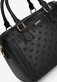 Black leather handbag with embossed floral pattern, double handles, and gold-toned hardware, featuring a zip closure and structured design.