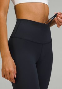 Svarta högmidjade leggings gjorda av stretchigt tyg, med en mjuk yta och en justerbar midjeresår med dragsko.