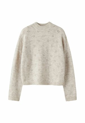 Pull beige en maille avec manches longues, col montant et petits motifs floraux ajourés répartis de manière homogène sur le tissu.