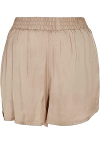 Shorts beige légers avec une taille élastique, texture lisse et coupe ample et fluide. L'ourlet présente une forme arrondie.