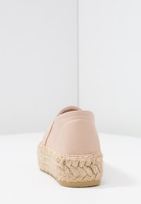Espadrille de cuero rosa con suela de yute trenzado, que presenta un ligero tacón y una textura suave. Detalle de costura lateral visible.