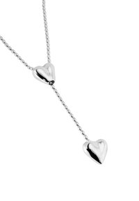 Collar de plata que presenta dos colgantes en forma de corazón pulidos, conectados por una cadena de cuentas, con una textura suave y una superficie reflectante.
