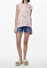 Květinová blůza z lehkého materiálu s volány na rukávech, v pastelových barvách růžové, oranžové a zelené. Spárováno s džíny šortkami a robustními sandály.