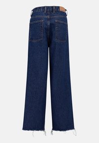 Jean en denim à jambes larges couleur bleu foncé, avec un ourlet effiloché, deux poches arrière, et une étiquette en cuir beige sur la taille.