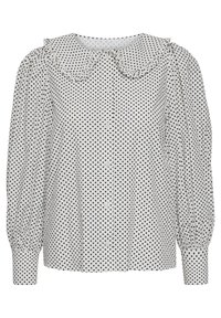 Blusa bianca con pois neri, dotata di un colletto Peter Pan arricciato, maniche lunghe a sbuffo e chiusura frontale con bottoni.