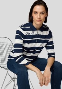 Marineblau-weiß gestreites Poloshirt mit einem Reißverschlusskragen und Dreiviertelärmeln, das mit dekorativem Schriftzug und Strassakzenten versehen ist.