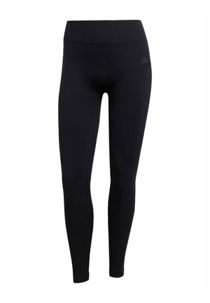 Leggings de sport noirs en tissu extensible, avec une taille haute, une coupe ajustée et des poignets côtelés aux chevilles. Logo de la marque subtile.