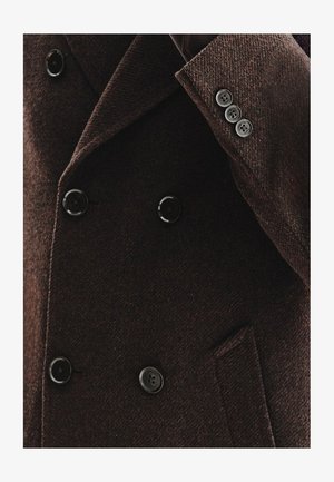 Brązowy płaszcz z mieszanki wełny, wyróżniający się teksturowanym materiałem, podwójnym zapięciem, dużymi czarnymi guzikami oraz dopasowanym kołnierzem.