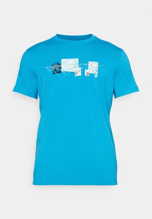 T-shirt à manches courtes de couleur turquoise vif, présentant un design imprimé de montagnes et de motifs abstraits dans plusieurs couleurs sur le devant.