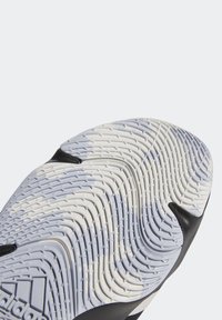 Gros plan d'une semelle de chaussure blanche et noire avec un motif de bande de roulement ondulé et texturé pour l'adhérence et la traction.