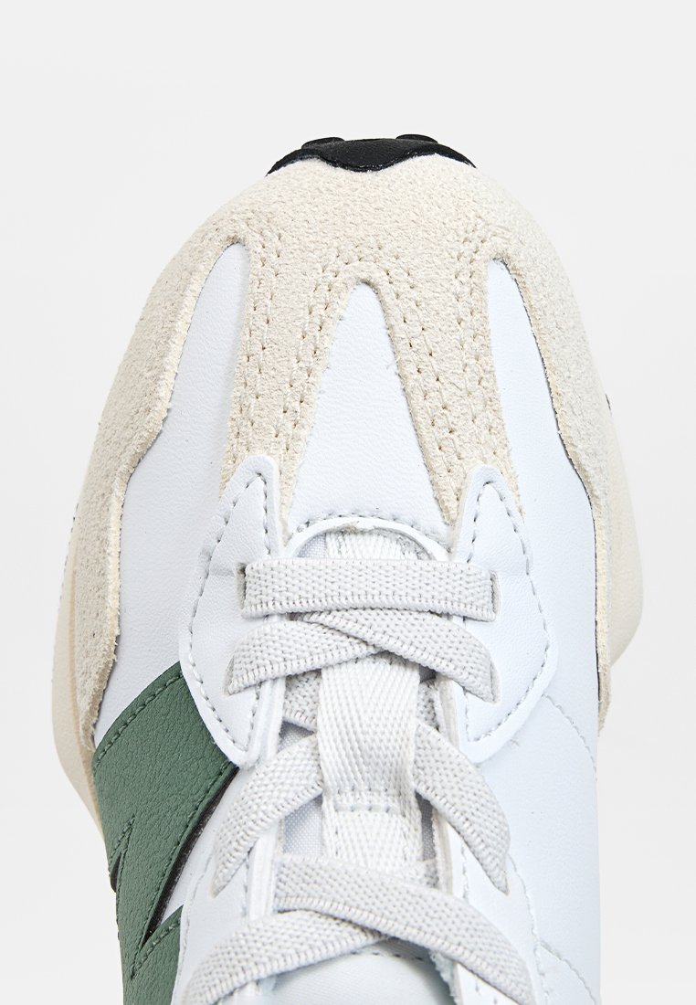 Baskets blanches avec des accents verts, dotées d'un embout en suede texturé et d'une tige en cuir lisse. Comprend des lacets plats et un détail noir au talon.