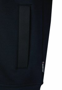 Marineblauwe sweatshirt met een gestructureerde zwarte mesh zak, vlakke naden en een klein merklabel in de rechteronderhoek.