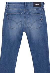Jeans de denim azul oscuro con corte recto, que cuentan con dos bolsillos traseros, costuras decorativas y una etiqueta de marca negra en la cintura.