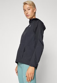 Lightweight black windbreaker jacket with a hood, zippered front pocket, and elastic cuffs; features a subtle logo on the chest.