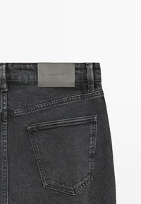 Ciemnoszare dżinsy o gładkiej fakturze, z tylną kieszenią i skórzaną metką z logo "Massimo Dutti" na pasku.