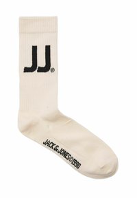 Bomuldsankelsok i cremefarve med sort "JJ" logo og "Jack & Jones 1990" tekst. Har ribbet top og glat tekstur.