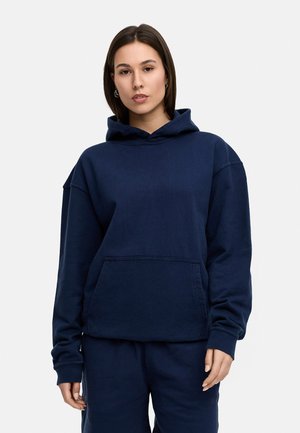Navy blue hooded sweatshirt made from soft material, featuring a front pocket, loose fit, and ribbed cuffs. Simple design with no patterns.