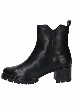 Botines negros de piel suave, con tacón cuadrado, suela dentada y una lengüeta en la parte trasera. Diseño monocromático con logo grabado.