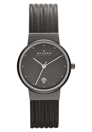 Rond zwart Skagen polshorloge met een mesh band, minimalistische wijzerplaat die 10:09 aangeeft, en een datumaanduiding op 6 uur.