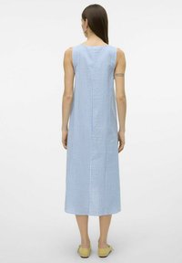 Plava i bijela prugasta haljina bez rukava, do gležnjeva, s ravnim siluetom, izrađena od lagane tkanine, s detaljno obrađenim stražnjim šavom.